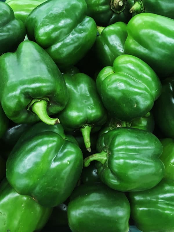 close up of a basket of green bell peppers